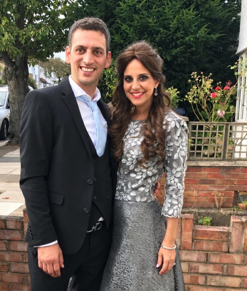 A young engaged couple seated together, smiling